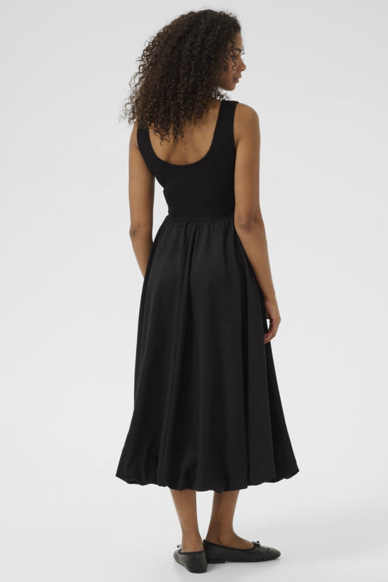 Woman wearing a black sleeveless dress on a white background
