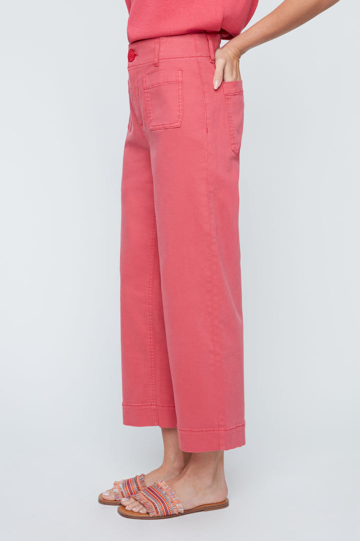 Person wearing pink pants and a matching top on a light gray background