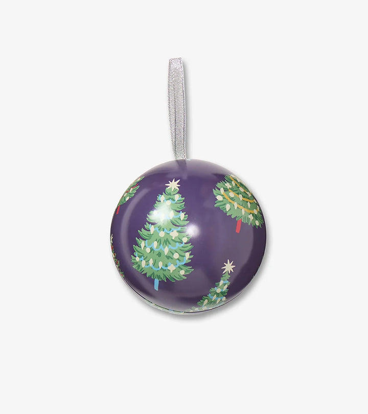 Round purple Christmas ornament with green trees on a white background