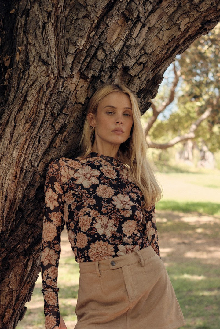 Woman leaning against a tree in a park