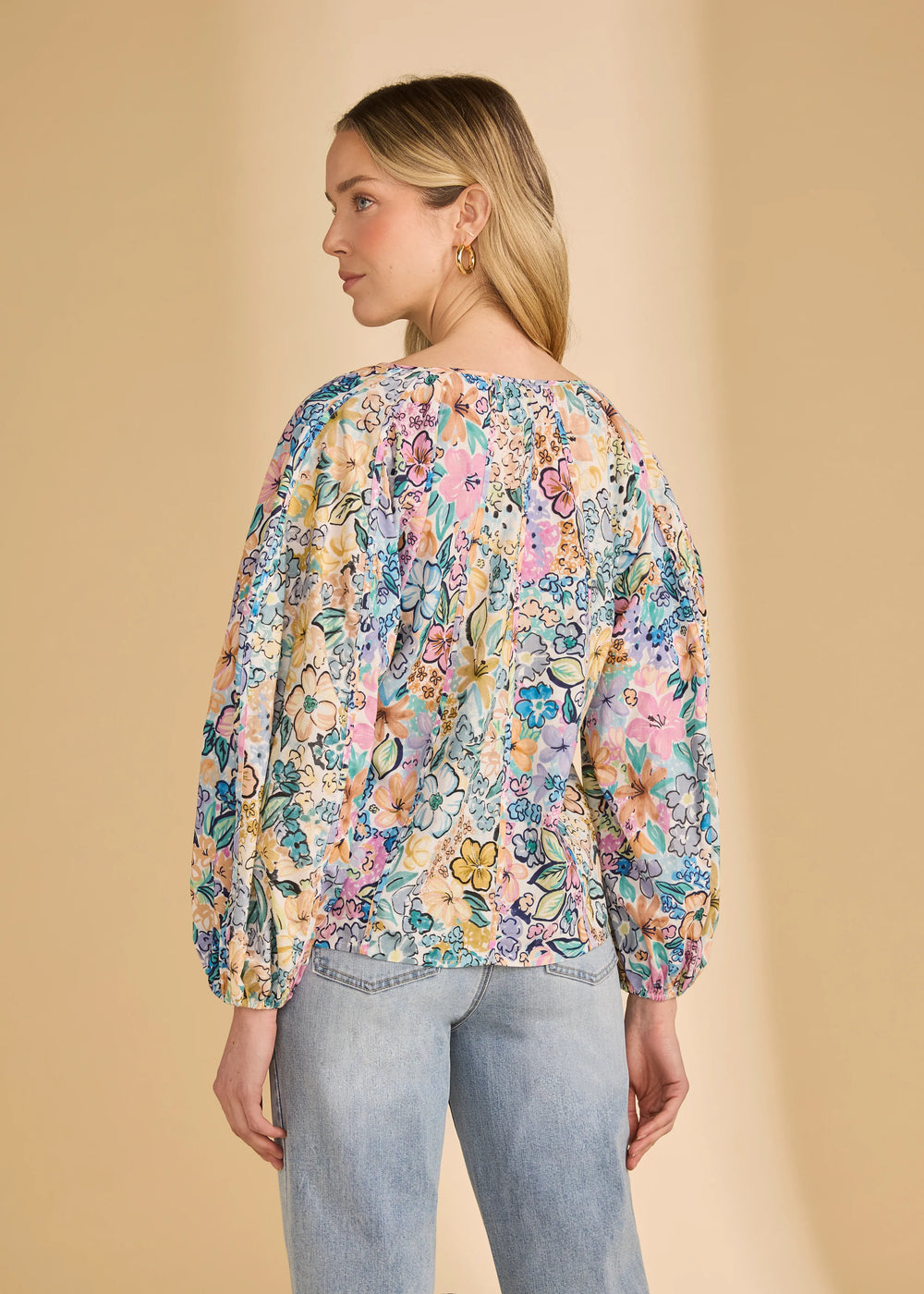 Woman wearing a floral blouse with a beige background