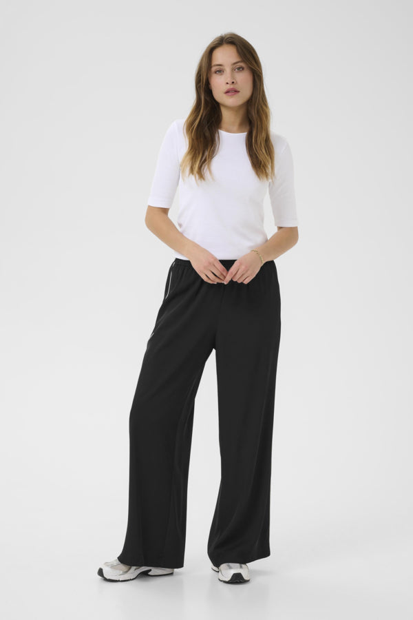 Woman wearing a white t-shirt and black pants on a white background