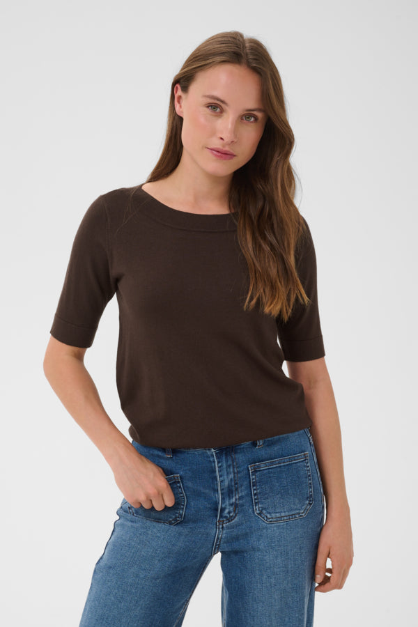 Woman wearing a brown shirt and blue jeans on a white background