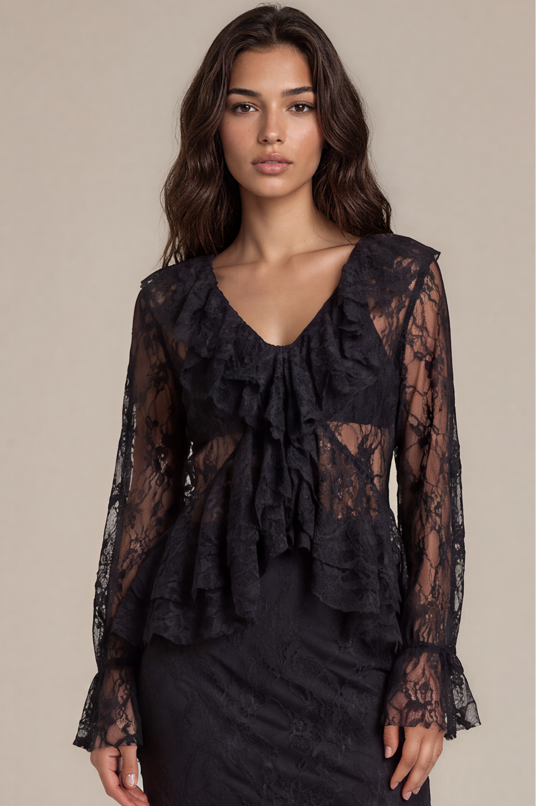 A model wears a black lace long-sleeve midi dress with a ruffled V-neckline and tiered hem, paired with black platform sandals, against a solid beige studio background.