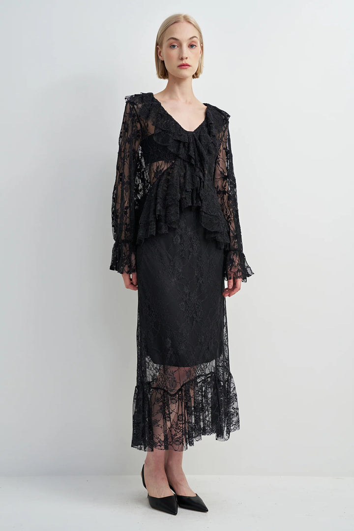 Woman wearing a black lace dress against a white background
