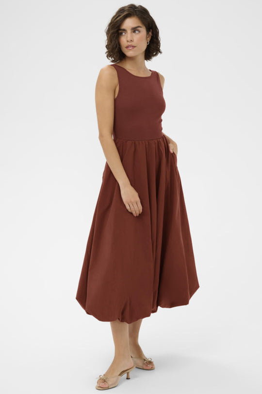Woman wearing a brown dress on a white background
