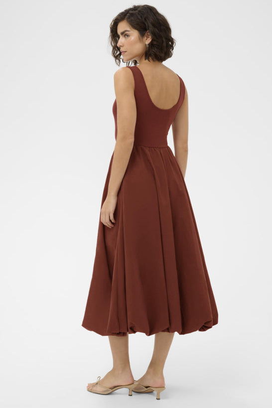 Woman wearing a brown dress on a white background