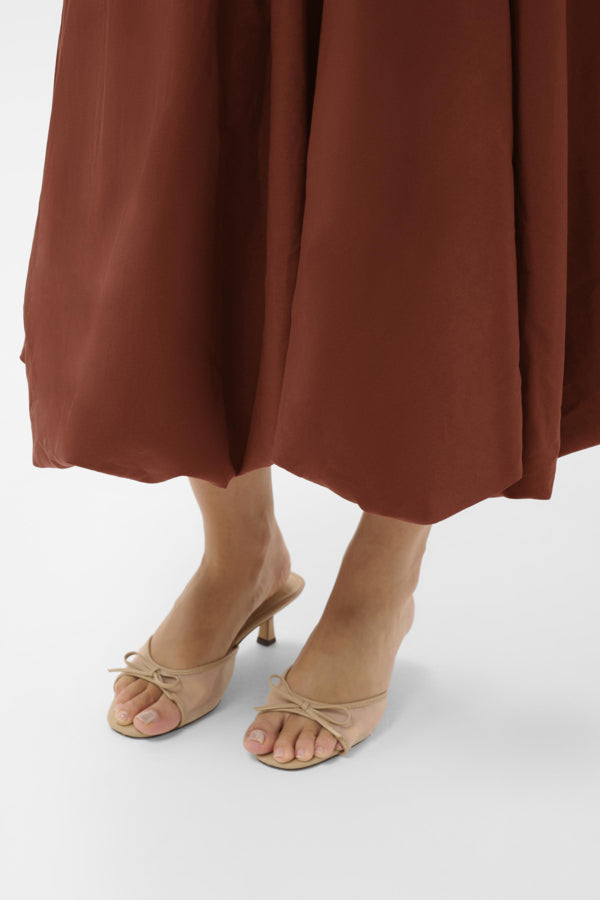 Brown skirt and beige high-heeled sandals on a white background
