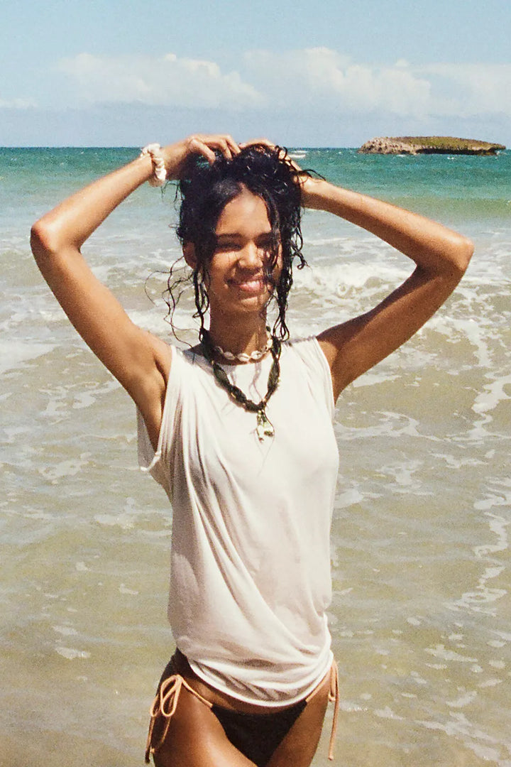 Woman standing on a beach with ocean and sky in the background