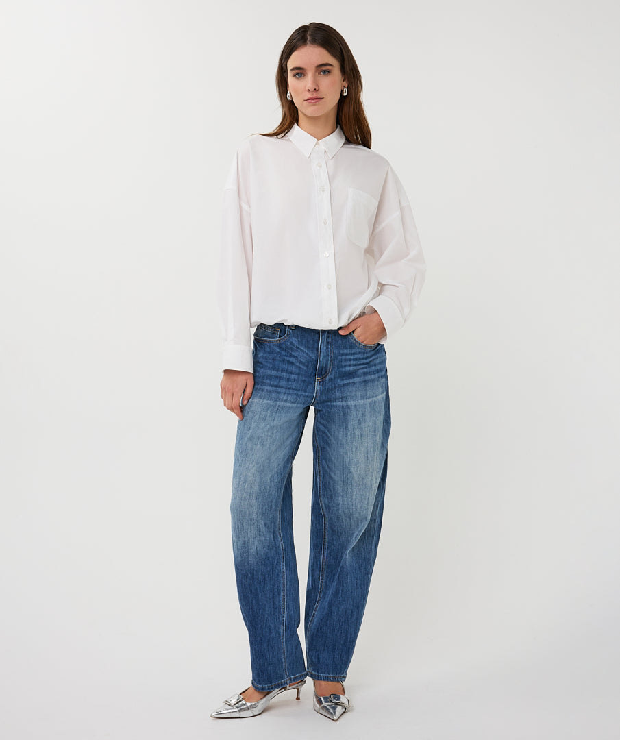 Woman wearing a white shirt and blue jeans on a white background