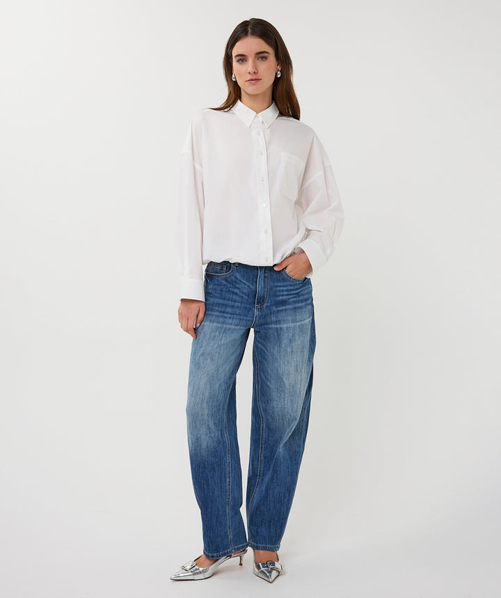 Woman wearing a white shirt and blue jeans on a white background
