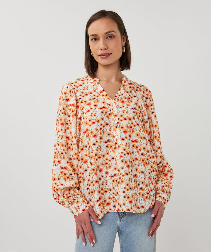 Woman wearing a floral blouse with a plain background