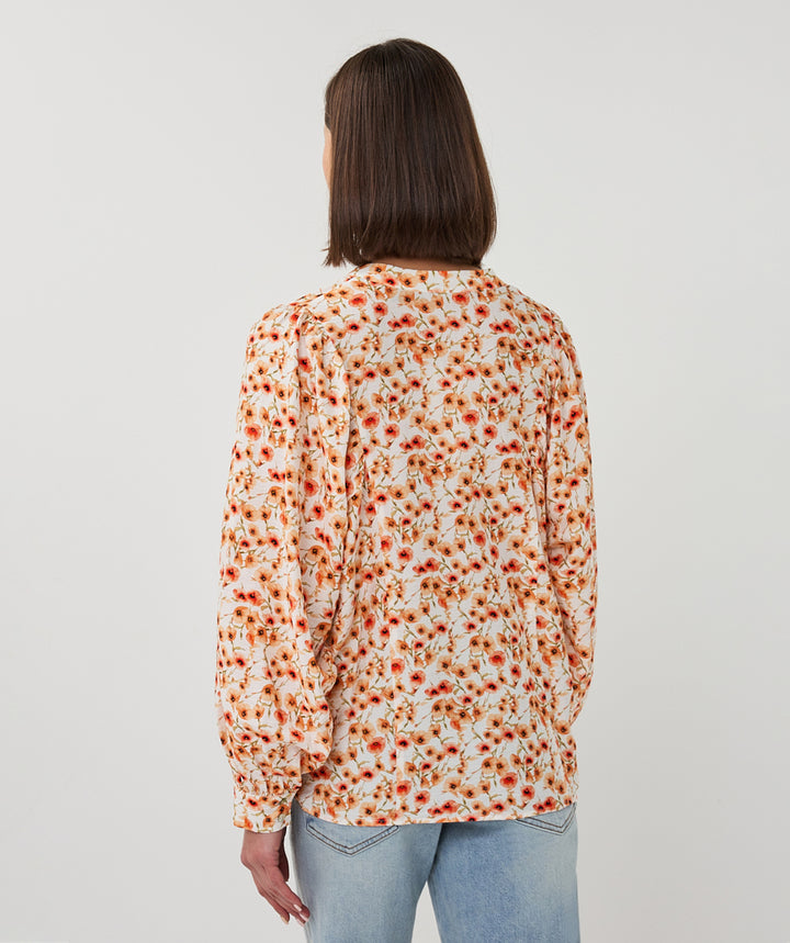Person wearing a floral blouse with a white background