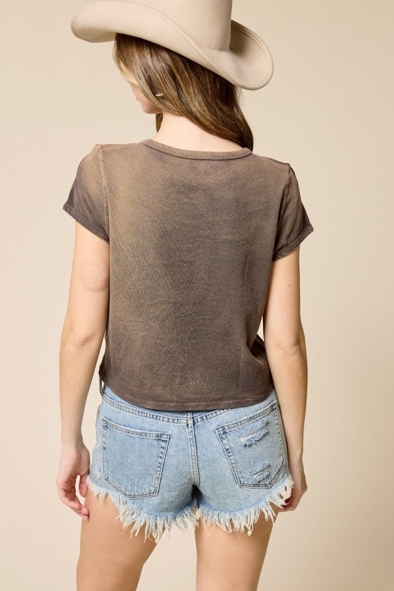 Person wearing a brown t-shirt and denim shorts with a beige hat on a beige background