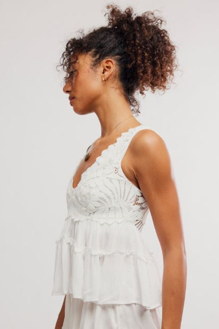 Woman wearing a white lace dress against a plain background