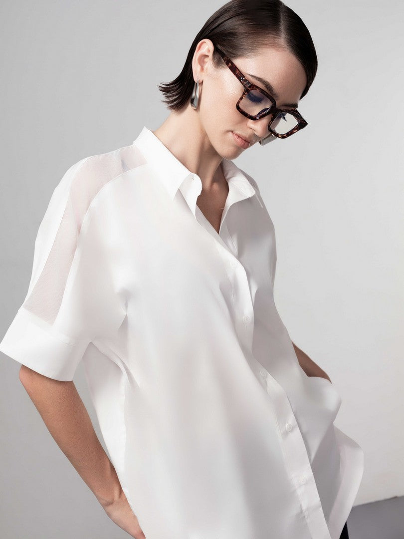 Woman wearing a white shirt against a gray background