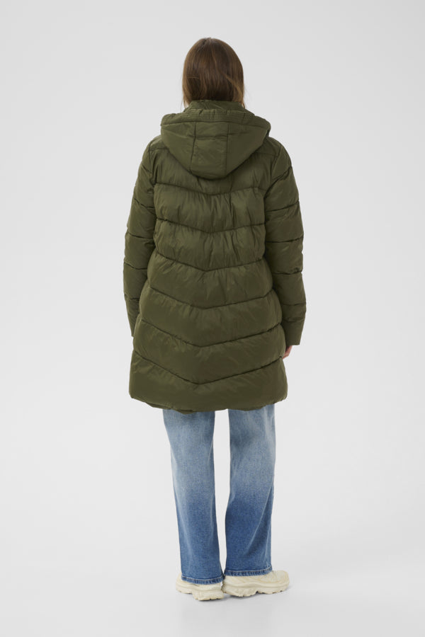 Person wearing a green puffer coat on a white background