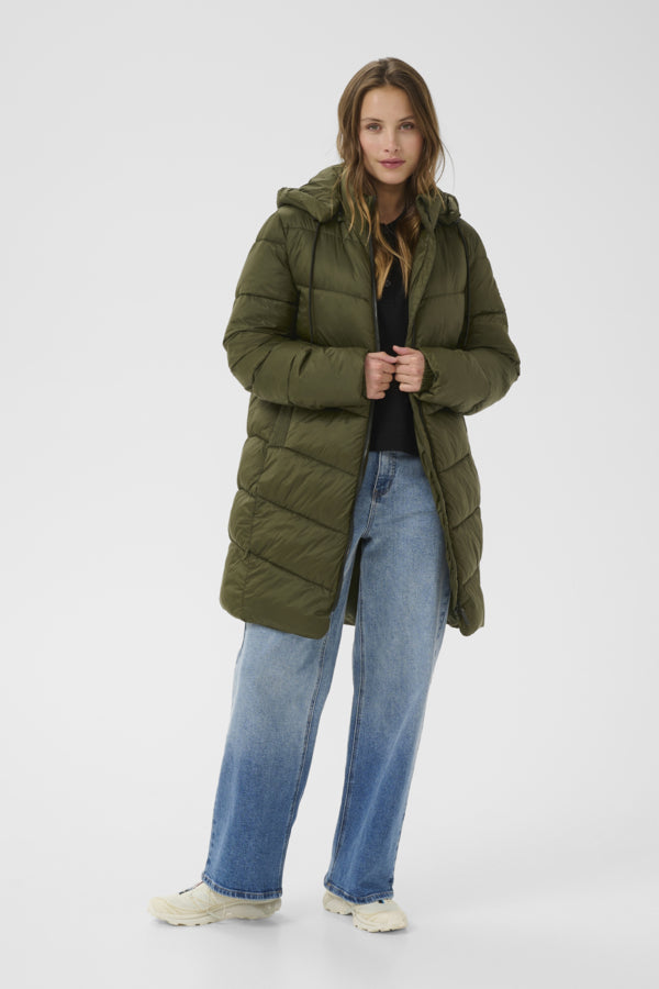 Woman wearing a green puffer coat on a white background