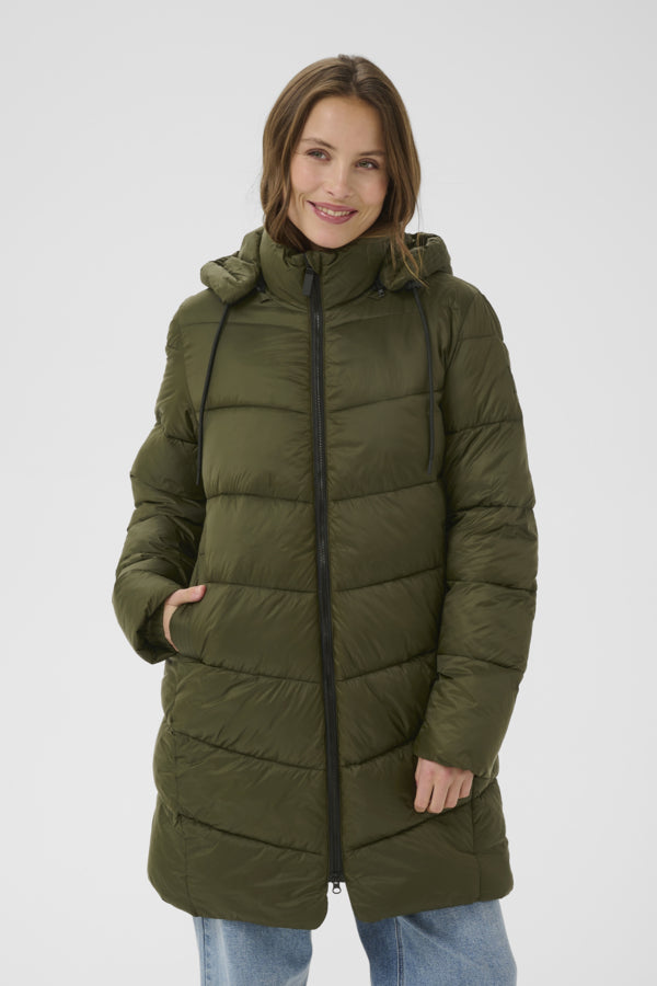 Woman wearing a green puffer coat on a white background