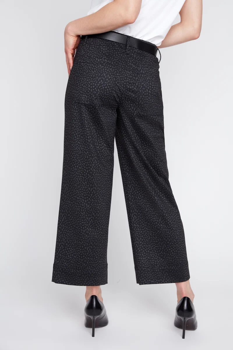 Person wearing black patterned pants on a white background