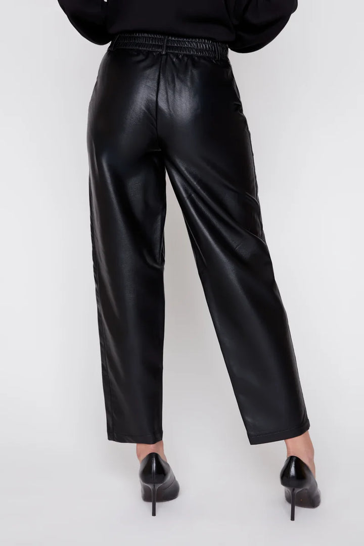 Person wearing black leather pants on a white background