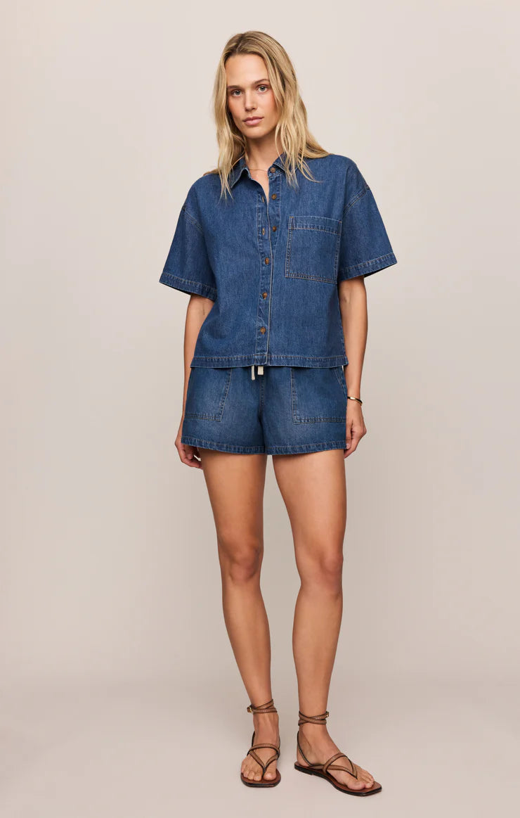 Woman wearing a denim outfit on a plain background