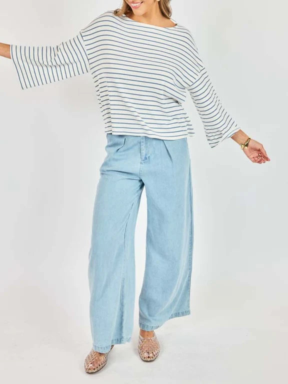 Person wearing a striped shirt and light blue jeans on a white background