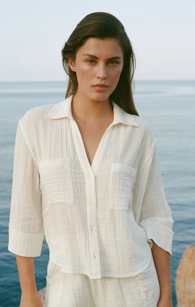 Woman wearing a white outfit standing by the ocean