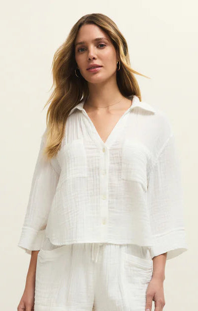 Woman wearing a white outfit on a plain background