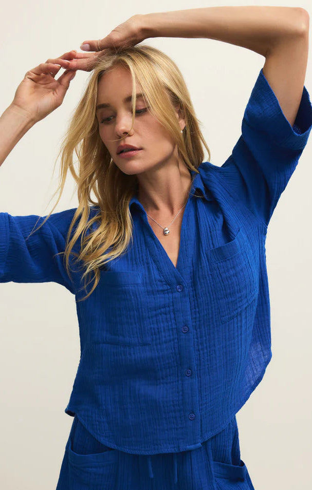 Woman wearing a blue outfit with a plain background
