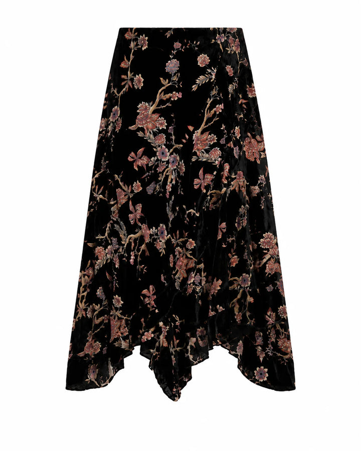 A black velvet midi skirt with an all-over floral print in dusty pink, mauve, and muted gold, featuring an asymmetrical draped hem.