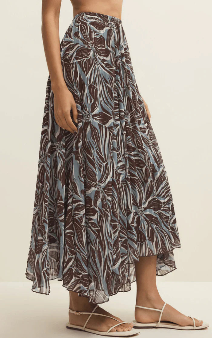 Long, patterned skirt worn by a person on a plain background