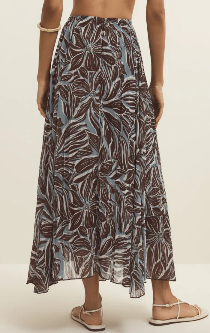 Person wearing a patterned skirt on a plain background