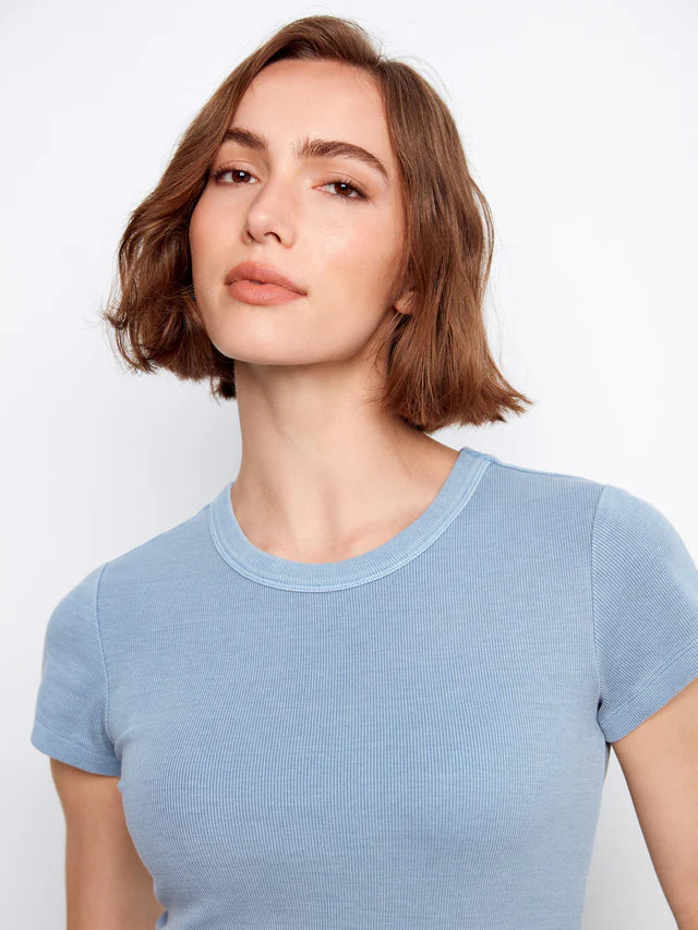 Woman wearing a light blue t-shirt against a plain background
