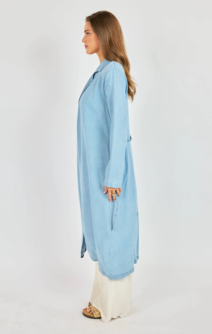 Woman wearing a light blue long shirt on a white background