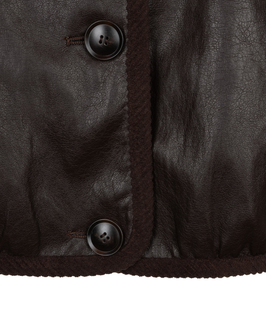 Close-up of a dark brown leather jacket showing the texture of the leather, a dark brown braided trim, and two dark brown buttons on a white background.