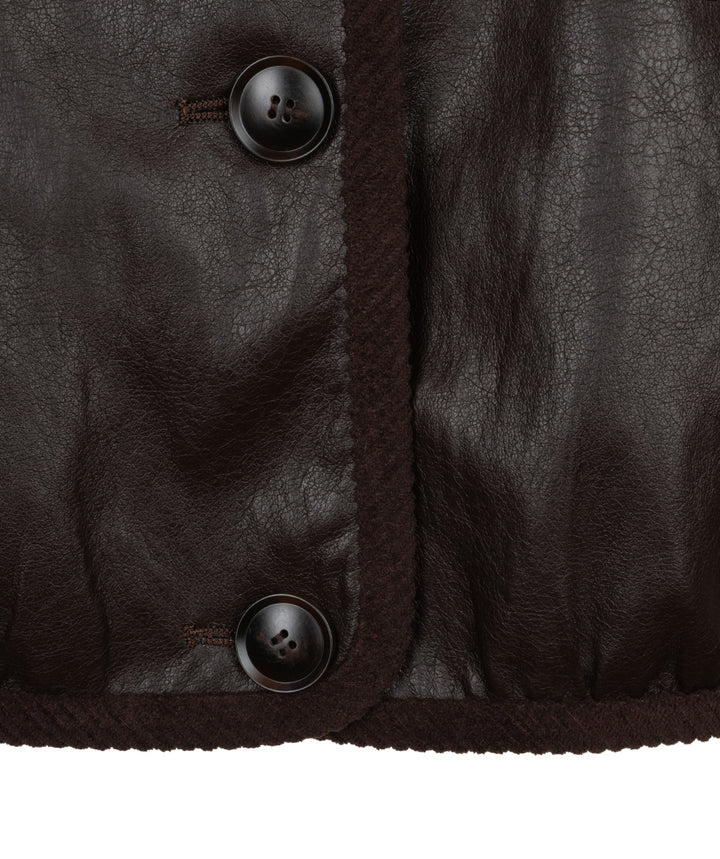 Close-up of a dark brown leather jacket showing the texture of the leather, a dark brown braided trim, and two dark brown buttons on a white background.