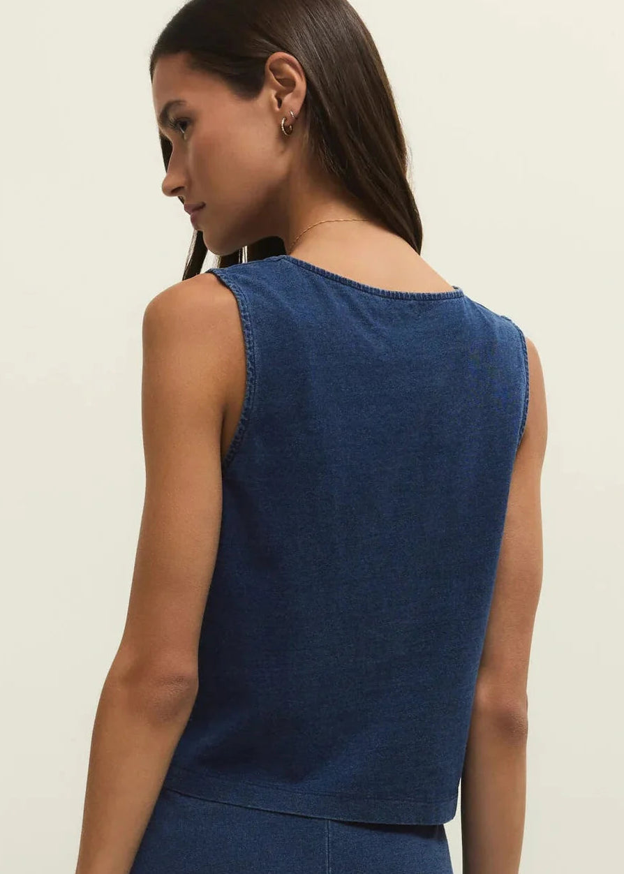 Woman wearing a blue sleeveless top against a beige background