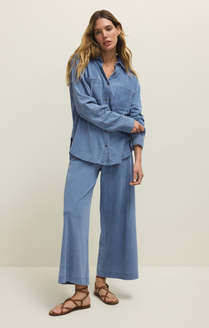 Woman wearing a blue denim outfit on a plain background
