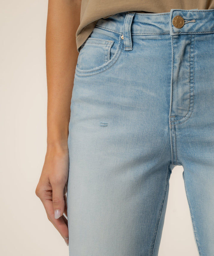 Light blue jeans worn by a person on a plain background
