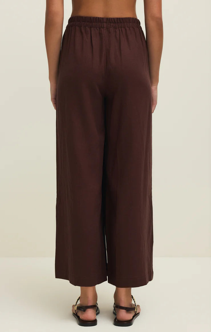 Brown wide-leg pants worn by a person on a white background