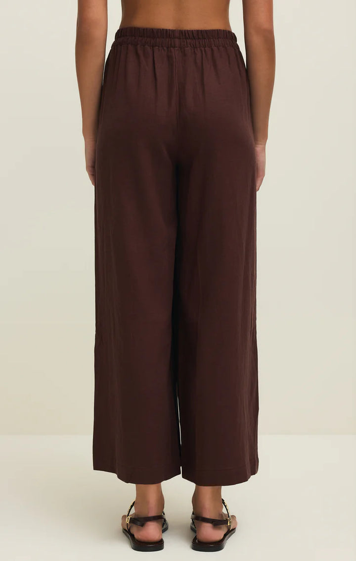 Brown wide-leg pants worn by a person on a white background