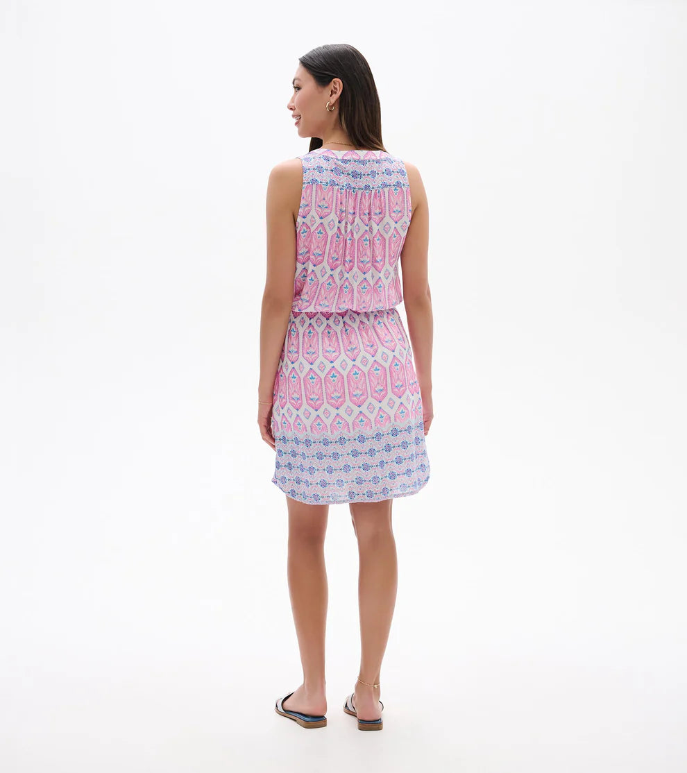 Woman wearing a sleeveless dress with a pink and blue pattern on a white background