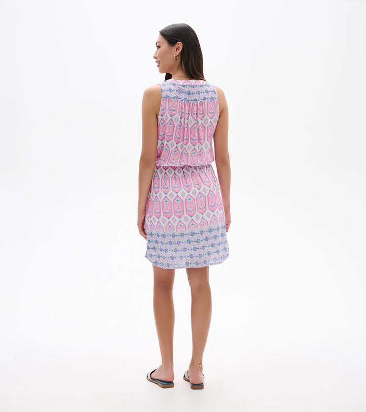 Woman wearing a sleeveless dress with a pink and blue pattern on a white background