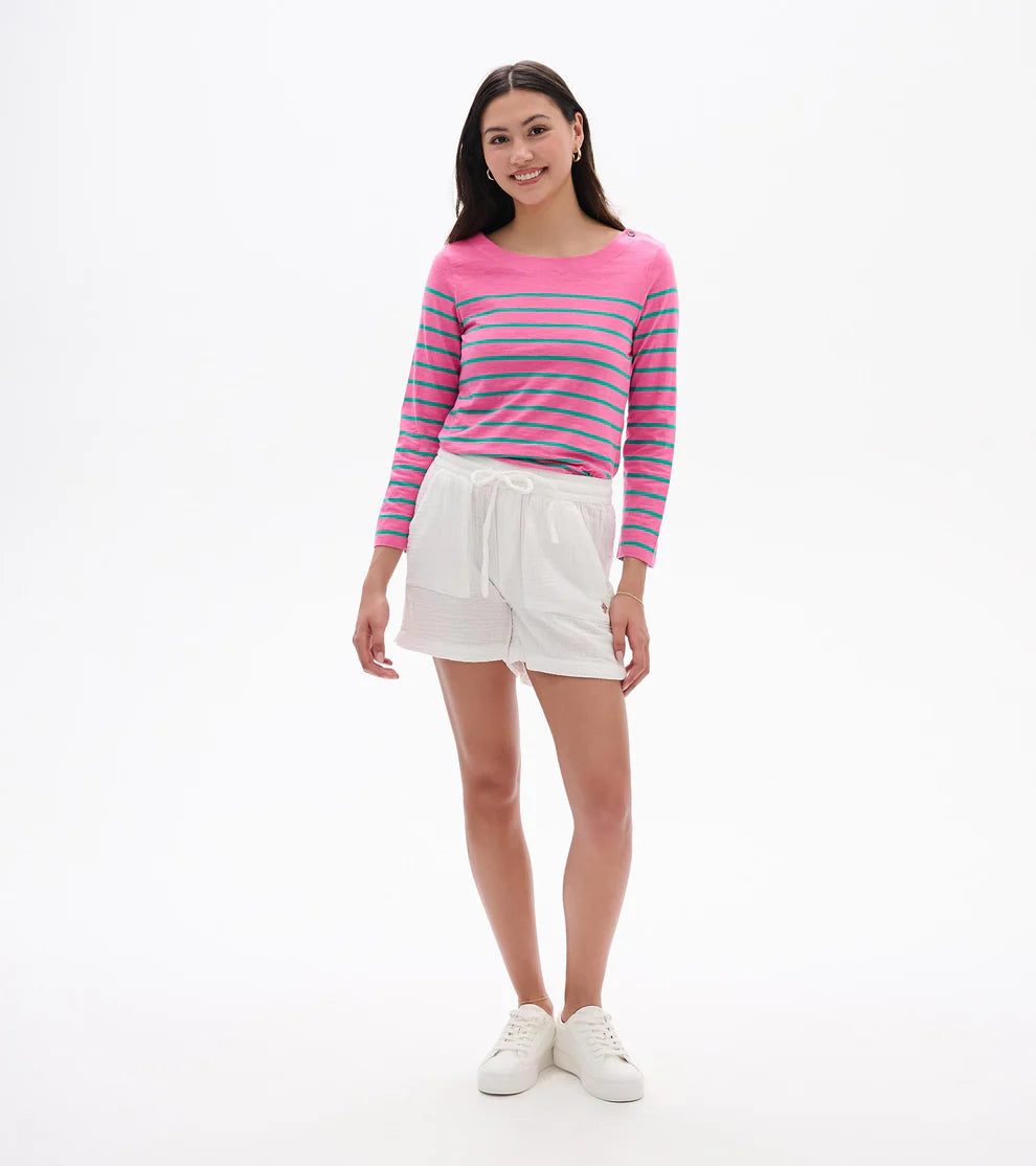 Woman wearing a striped pink and blue sweater with white shorts on a white background