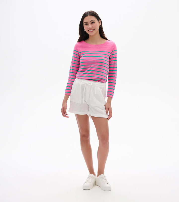 Woman wearing a striped pink and blue sweater with white shorts on a white background
