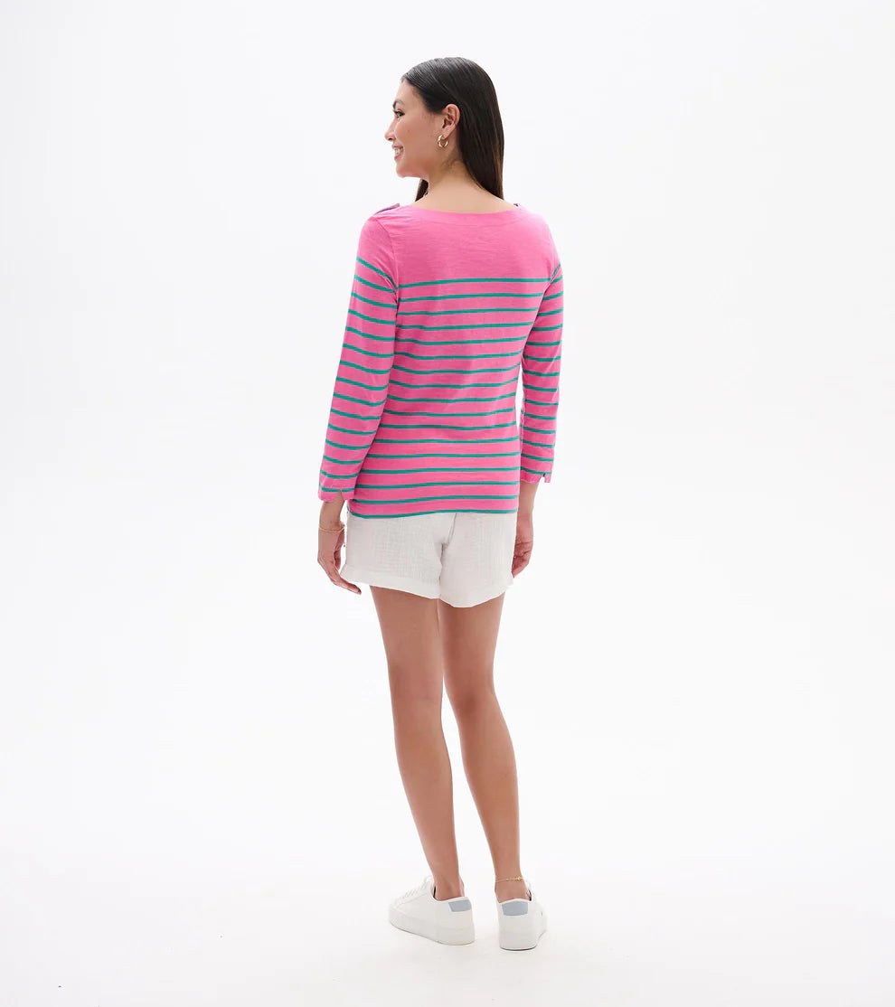 Woman wearing a pink and blue striped sweater with white shorts on a white background