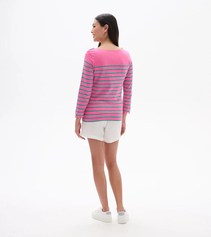 Woman wearing a pink and blue striped sweater with white shorts on a white background