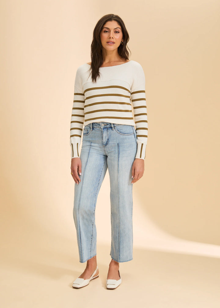 Woman wearing a striped sweater and jeans on a beige background
