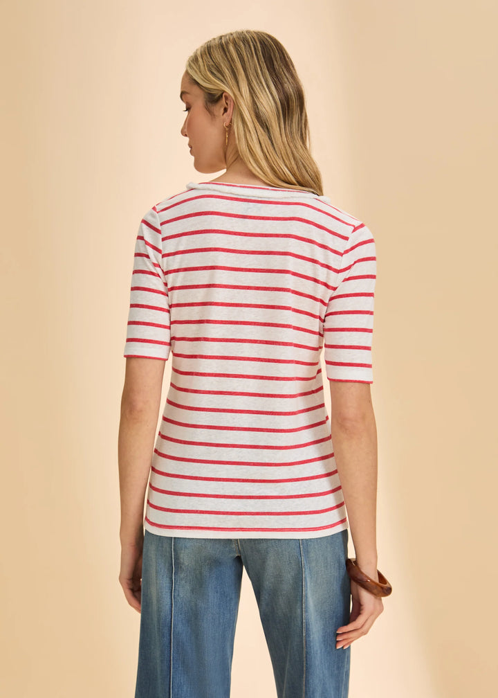 Woman wearing a red and white striped shirt and blue jeans on a beige background